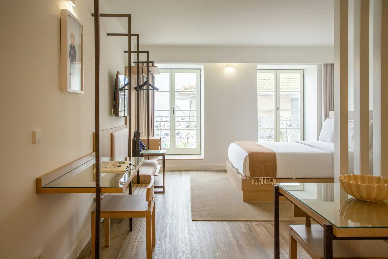 Representative image: a hotel room with a bed, desk, chairs and a television
