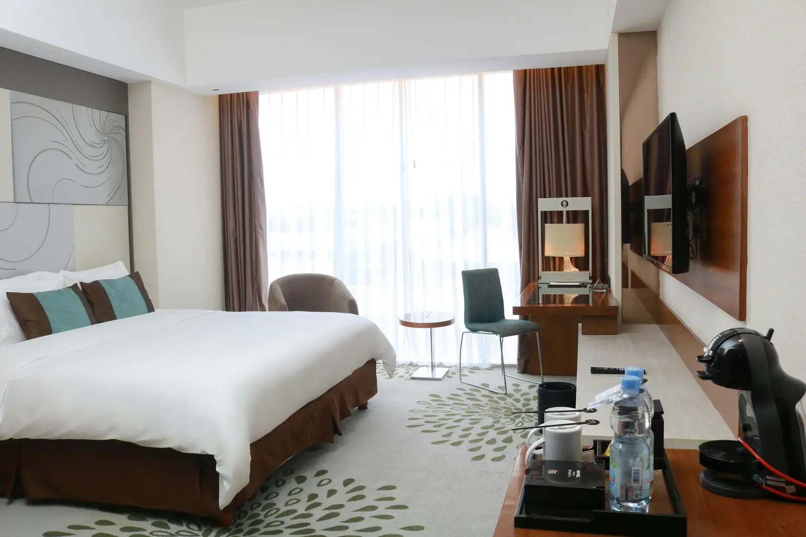 Representative image: a hotel room with a large bed and a flat screen TV