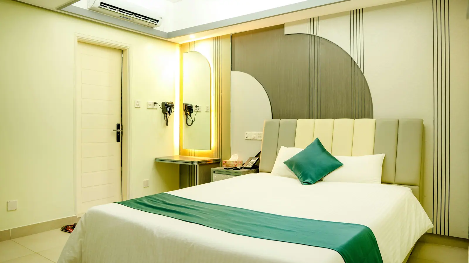 Representative image: a hotel room with a bed, green runner and a wall-mounted air conditioner